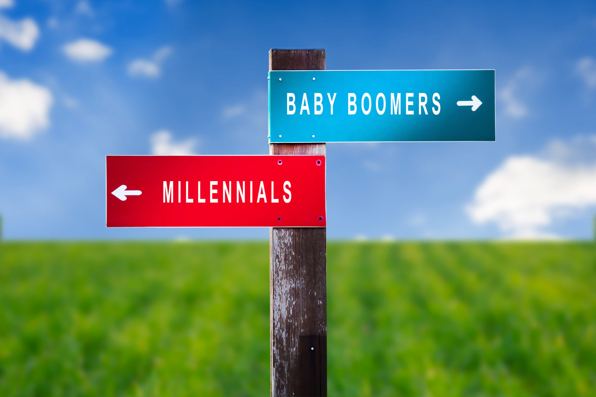 Road signs pointing in opposite directions labeled 'Baby Boomers' and 'Millennials' representing generational real estate wealth divide